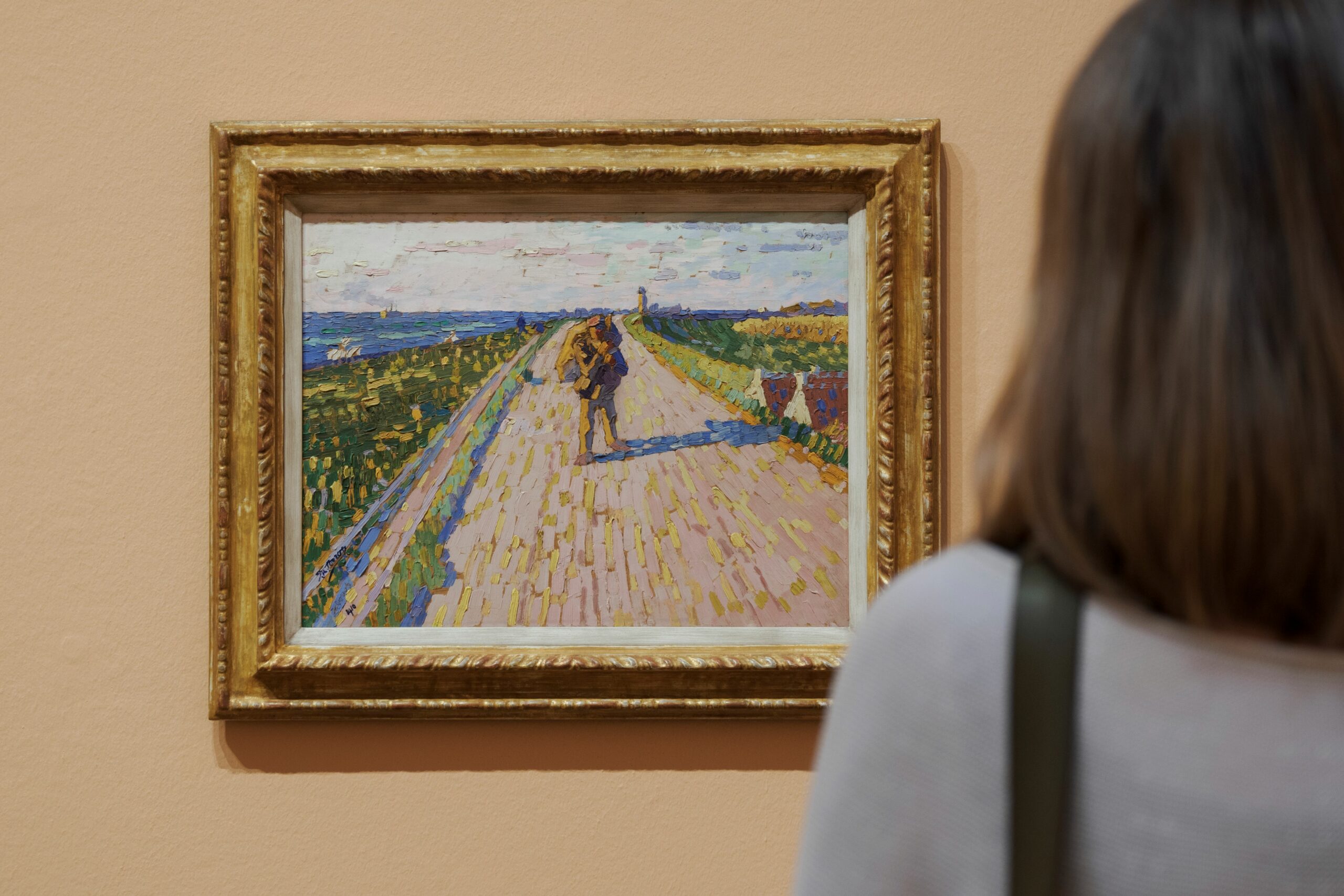 Besucherin betrachtet ein Gemälde im Museum Kunst der Westküste auf Föhr