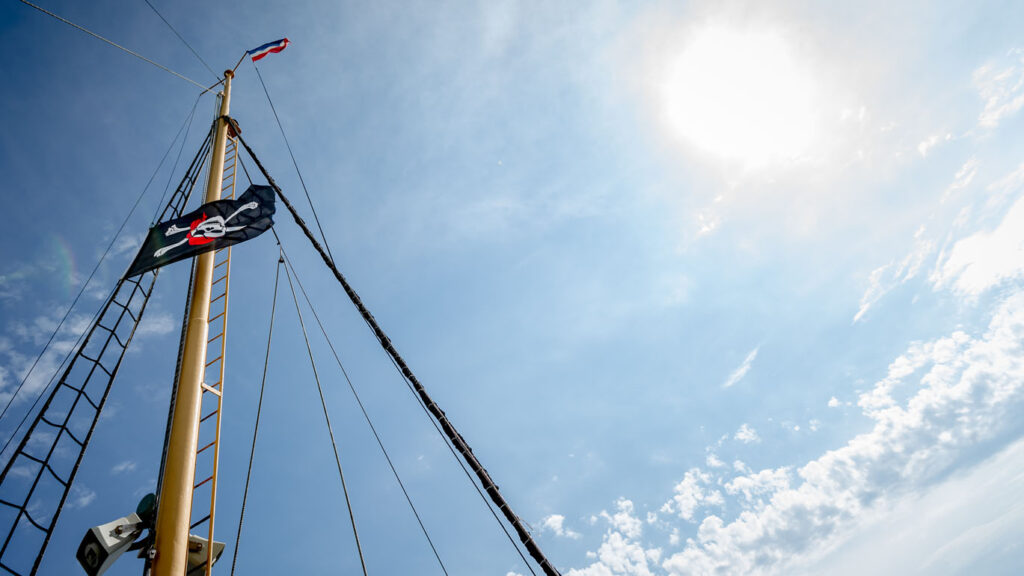 Mast mit Piratenflagge vor dem Himmel bei einer Piratenfahrt mit Kindern