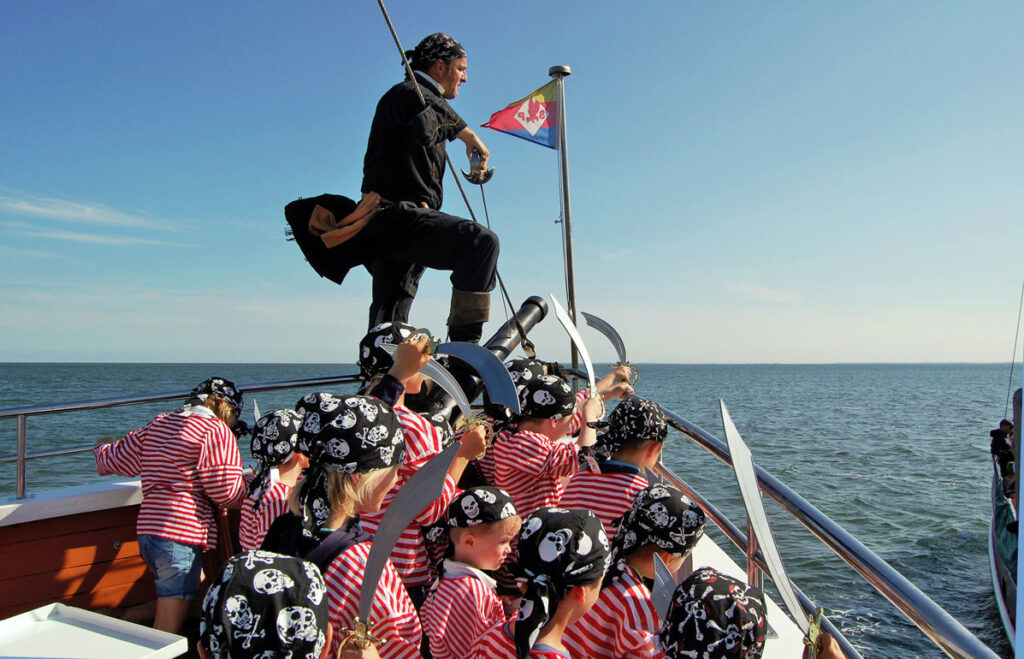 Piratenkapitän mit seiner jungen Crew an Bord einer Adler-Schiffe Piratenfahrt